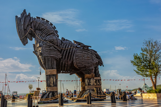  Imagem com fundo de céu azul e nuvens brancas, ilustra uma réplica de um cavalo de Troia para visitação na cidade turca de Çanakkale em tamanho real que, segundo o mito, teria 4 metros de largura e 7 de altura